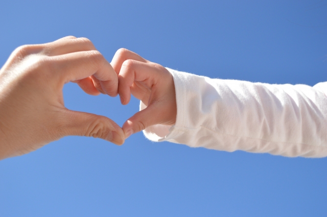 親と子どもが手でハートを作っている